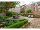 Idyllic backyard oasis with a brick patio, dining set, lounge chairs, and beautifully manicured greenery at 2 Bedons Aly, Charleston, SC 29401