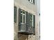 Charming exterior balcony with black iron railings and shutters adding character to the facade at 2 Bedons Aly, Charleston, SC 29401