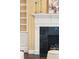 Detailed view of fireplace with black marble surround and white mantle flanked by built in shelves at 2 Bedons Aly, Charleston, SC 29401