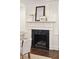 Close up of the fireplace featuring a marble surround, white mantle, and artwork above at 2 Bedons Aly, Charleston, SC 29401