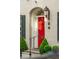 Inviting front entrance featuring a red door, decorative lantern, and manicured landscaping at 2 Bedons Aly, Charleston, SC 29401