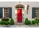 Inviting facade featuring a vibrant red door, complemented by classic architectural details and lush landscaping at 2 Bedons Aly, Charleston, SC 29401