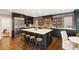 Bright kitchen featuring dark cabinets, stainless appliances, a brick accent wall, and an island at 2 Bedons Aly, Charleston, SC 29401