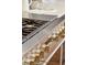 Close-up of a high-end stainless steel kitchen range with brass knobs and burners at 2 Bedons Aly, Charleston, SC 29401