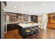 Spacious kitchen with large island, black cabinets, stainless appliances, and brick accent wall at 2 Bedons Aly, Charleston, SC 29401