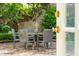 Outdoor patio featuring a dining table, chairs, brick paving, and lush greenery at 2 Bedons Aly, Charleston, SC 29401