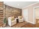 Cozy sitting area features exposed brick, stylish chairs, and a brick paver floor at 2 Bedons Aly, Charleston, SC 29401