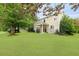 Expansive backyard with lush green lawn, mature trees, and a covered patio for outdoor enjoyment at 200 Commencement Blvd, Ladson, SC 29456