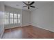 Bright bedroom with hardwood floors, ceiling fan, and a large window with white shutters at 2036 Kings Gate Ln, Mount Pleasant, SC 29466