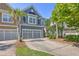 Charming blue two-story townhouse featuring an attached two-car garage and a meticulously maintained front yard at 2036 Kings Gate Ln, Mount Pleasant, SC 29466