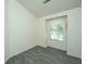 Bright bedroom featuring gray vinyl flooring and a sunlit window with decorative curtains at 207 Apache Dr, Summerville, SC 29483