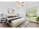 Bright primary bedroom features a modern ceiling fan, a large window, carpet, and modern decor at 207 Terry Ave, Summerville, SC 29485