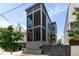 Charming two-story home with a screened porch, yellow door, and gray picket fence for added curb appeal at 211 Line St, Charleston, SC 29403