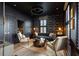 Sophisticated living room with a dark moody color palette, library wallpaper, and unique lighting at 211 Line St, Charleston, SC 29403