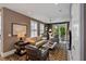 Bright living room with a tan leather sofa, patterned rug, and access to the patio at 211 Line St, Charleston, SC 29403