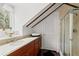 Bathroom with marble countertop, wood cabinets, and shower with glass door and a window at 22 Lamboll St # C, Charleston, SC 29401