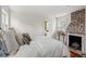 Comfortable bedroom featuring an exposed brick fireplace and a bright ensuite bathroom at 22 Lamboll St # C, Charleston, SC 29401