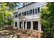 Stately white home with dark green shutters, complemented by an outdoor brick patio and seating area at 22 Lamboll St # C, Charleston, SC 29401