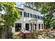 Elegant white home with black shutters featuring an inviting outdoor patio with dining and seating areas at 22 Lamboll St # C, Charleston, SC 29401