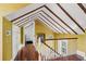 Hallway features exposed beams, hardwood floors, textured wallpaper and a view to a bedroom and bathroom at 22 Lamboll St # C, Charleston, SC 29401