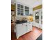 Kitchen area with white cabinets, glass-front display cases, and access to an outdoor patio at 22 Lamboll St # C, Charleston, SC 29401