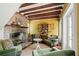 Cozy living room with exposed wood beams, a brick fireplace, and comfortable seating for relaxation at 22 Lamboll St # C, Charleston, SC 29401