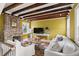Cozy living room with a brick fireplace, wood beam ceiling, and comfortable white sofas at 22 Lamboll St # C, Charleston, SC 29401