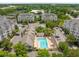 Aerial view of complex with community pool, sun loungers and ample parking surrounded by mature trees at 2244 Ashley Crossing Dr # 1125, Charleston, SC 29414