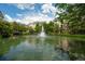 Community pond and water feature framed by trees with views of the apartment buildings at 2244 Ashley Crossing Dr # 1125, Charleston, SC 29414