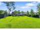 Expansive backyard featuring lush green grass, palm trees, and a privacy fence, perfect for outdoor activities at 2331 Brinkley Rd, Johns Island, SC 29455