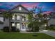 Charming two-story home with a double porch, mature trees, and a well-manicured lawn at dusk at 2331 Brinkley Rd, Johns Island, SC 29455