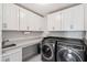 Well-lit laundry room with modern washer, dryer, sink, and ample counter space with white cabinets above and below at 2331 Brinkley Rd, Johns Island, SC 29455