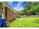 Large, grassy backyard with brick exterior and wood privacy fence at 2456 Lantern St, Charleston, SC 29414