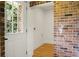 Mud room with brick accent wall, exterior door, and hardwood floors at 2456 Lantern St, Charleston, SC 29414
