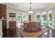 Elegant dining room featuring hardwood floors, a rustic wood table, and bright natural light from large windows at 2494 Cape Rd, Johns Island, SC 29455
