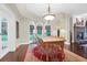 Bright dining room area featuring hardwood floors, a rustic wood table, and bright natural light from large windows at 2494 Cape Rd, Johns Island, SC 29455