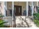 Close-up of the front porch with rocking chairs and double front doors at 2494 Cape Rd, Johns Island, SC 29455