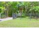 A gated entrance provides privacy to a lush property with a long tree-lined gravel driveway at 2494 Cape Rd, Johns Island, SC 29455