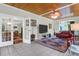 Spacious living room featuring tiled floors, wood-planked ceiling, a ceiling fan, and large windows at 2494 Cape Rd, Johns Island, SC 29455