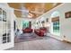 Open living area featuring wood-planked ceiling, arched windows, stylish decor, and comfortable sofas at 2494 Cape Rd, Johns Island, SC 29455