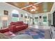 Bright living room with wood-planked ceiling, arched windows, a stylish ceiling fan, and comfortable seating at 2494 Cape Rd, Johns Island, SC 29455