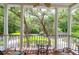 View from a covered porch with columns and wooden floors overlooking the property's landscaped grounds at 2494 Cape Rd, Johns Island, SC 29455