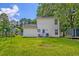 Large backyard with a well-maintained lawn, a small patio area with chairs, and an storage container in the distance at 2538 Wayne Scott Ct, Charleston, SC 29414
