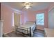 Inviting bedroom with pink walls, lots of light and a dark metal bed frame at 2538 Wayne Scott Ct, Charleston, SC 29414