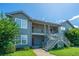 Well-maintained two-story condo building with gray siding, metal stairs, and green lawn under a clear blue sky at 2601 Riverridge Ct # A, Moncks Corner, SC 29461