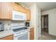 Bright kitchen with white appliances, wooden cabinets, and a view into the hall at 2601 Riverridge Ct # A, Moncks Corner, SC 29461