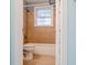 Cozy bathroom with tiled floors and walls, a bathtub, a toilet, and a window for natural light at 2736 Star Drive, North Charleston, SC 29406