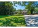 Charming home with a landscaped front yard, mature trees, and a gravel driveway at 3002 Waterway Blvd, Isle of Palms, SC 29451