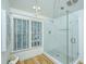 Elegant glass shower with white subway tile, hexagon tile floor, and a bright window at 3002 Waterway Blvd, Isle of Palms, SC 29451
