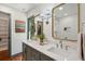 Bright bathroom features a double sink vanity, quartz countertop, gold framed mirrors, and artwork at 338 Mcclellan Ave, McClellanville, SC 29458